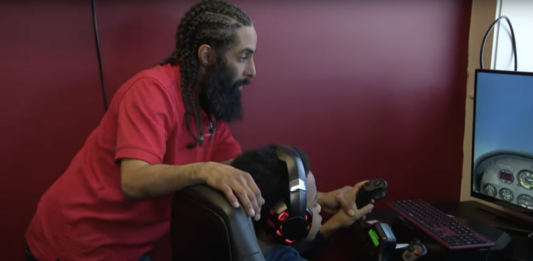 Instructor teaches young student using a flight simulator.