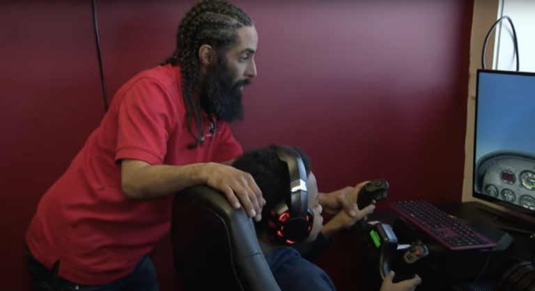 Instructor teaches young student using a flight simulator.