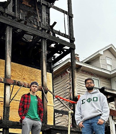 Sigma Phi Omicron brothers Rohan Solanki, right, and Arseniy Ohorilko in front of the duplex where they rescued several people from a fire.