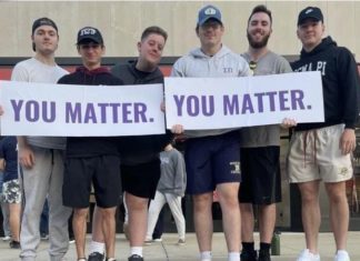 Sigma Pi fraternity members holding signs at a you matter event.