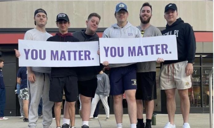 Sigma Pi fraternity members holding signs at a you matter event.
