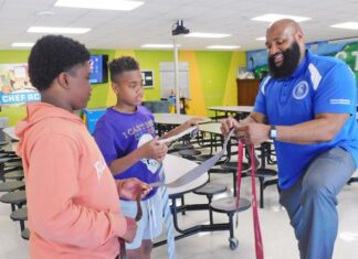 Franklin Teague, assistant principal of the MicroSociety Magnet Elementary School, tells Terrance Lattimore (left) and Coye Phillips about their new ties on Thursday.