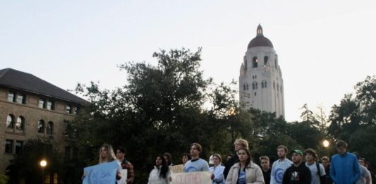 Students silently march past Hoover Tower to show solidarity for survivors of sexual assault on Tuesday evening. Photo: MARK ALLEN CU/The Stanford Daily.