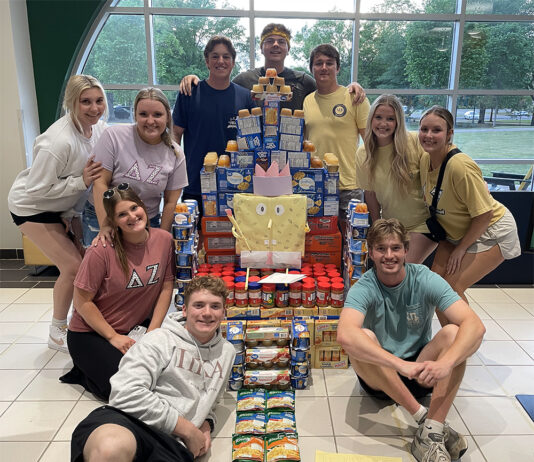 Arkansas Tech University Greek Life members pose with food collected for children in the Arkansas River Valley.