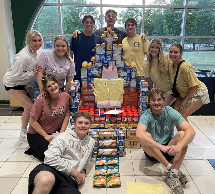 Arkansas Tech University Greek Life members pose with food collected for children in the Arkansas River Valley.