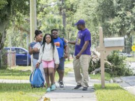 Barrette Walker, right, talks to students from Burroughs-Molette Elementary as he walks them to a summer camp Friday. Michael Hall/The Brunswick News