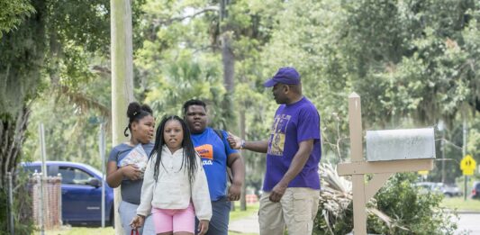 Barrette Walker, right, talks to students from Burroughs-Molette Elementary as he walks them to a summer camp Friday. Michael Hall/The Brunswick News