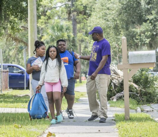 Barrette Walker, right, talks to students from Burroughs-Molette Elementary as he walks them to a summer camp Friday. Michael Hall/The Brunswick News