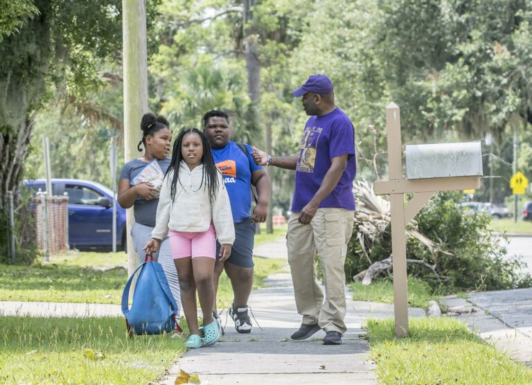 Barrette Walker, right, talks to students from Burroughs-Molette Elementary as he walks them to a summer camp Friday. Michael Hall/The Brunswick News